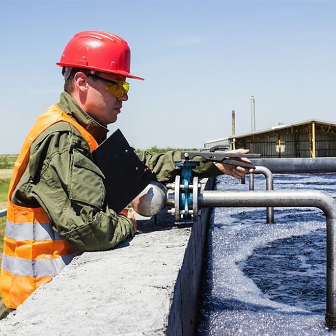 Ion Agua engineer sampling water at the edge of an aeration basin